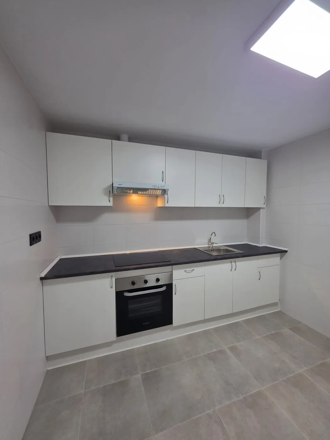 Montaje de cocina blanca con horno y campana en Murcia