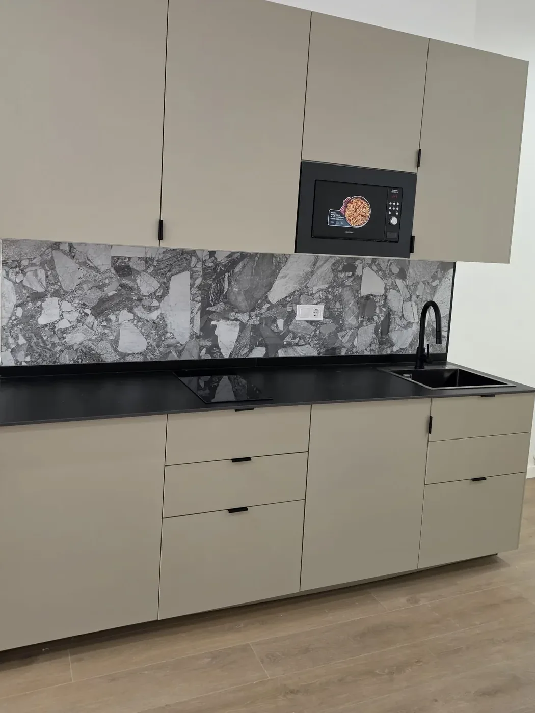 Cocina montada con encimera negra y fregadero en Murcia